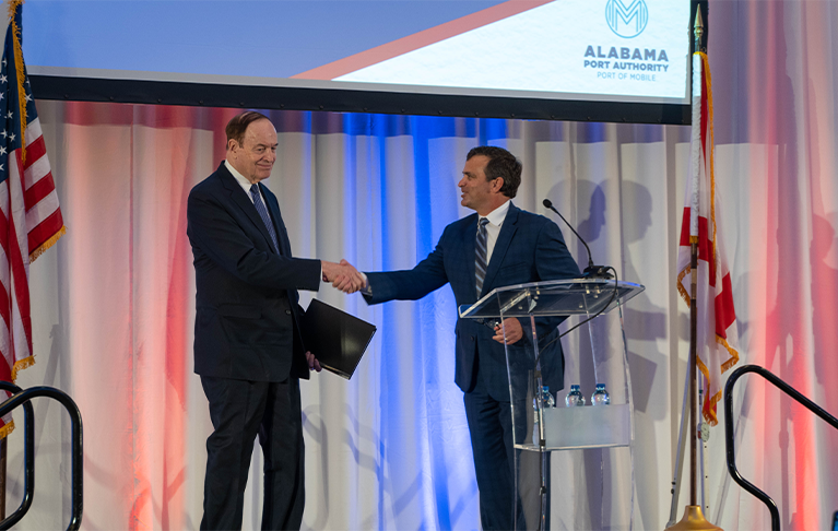 two men shaking hands on stage