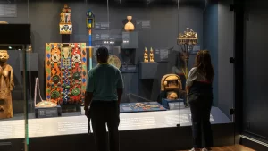 People viewing artifacts through glass at Clotilda: the Exhibition