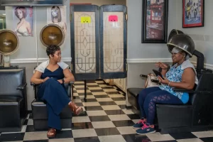 Photo of two ladies sitting under hair dryers at the salon.